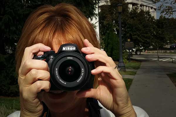 Image of woman holding a Nikon camera